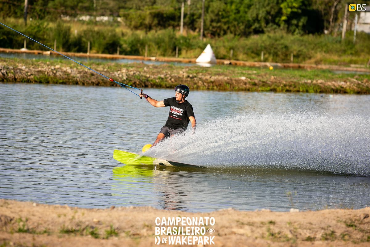 Praticante de wakeboard fazendo uma curva com respingo de água
